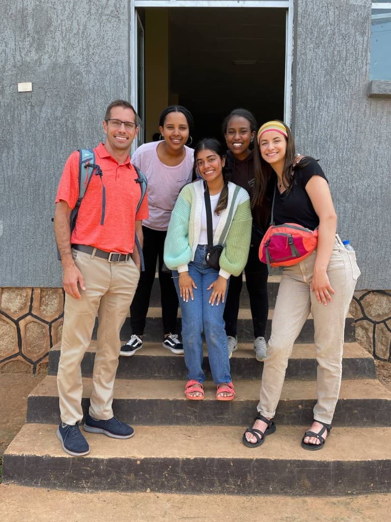 Mission trip volunteers posing together on the steps of a community building in Ethiopia