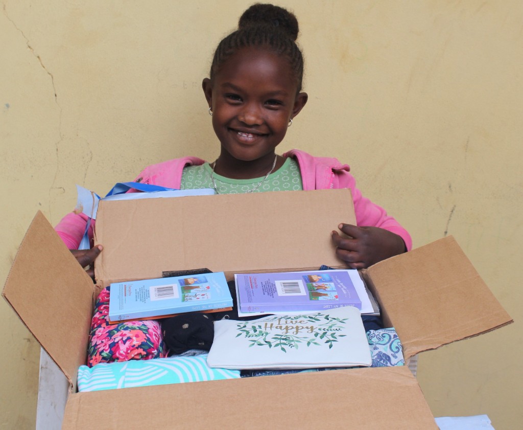 Child receiving a special gift package from a sponsor