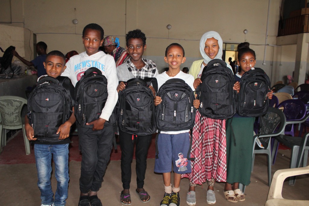 Children receiving school bags during a distribution event
