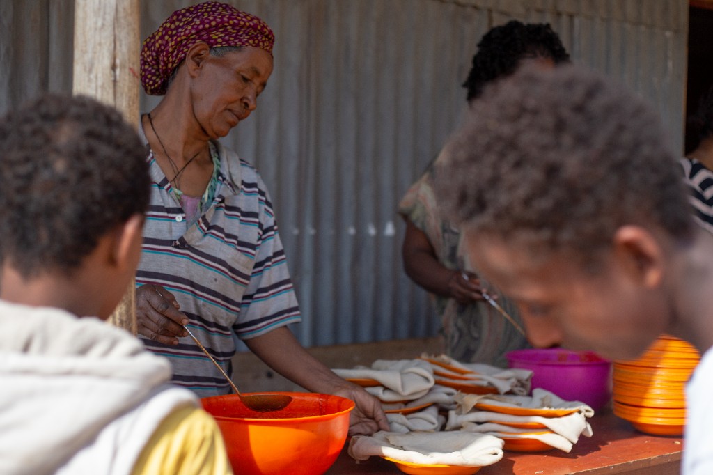 Food distribution line with children and volunteers