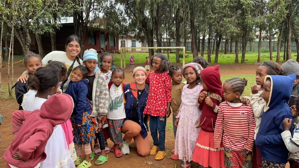 Mission trip volunteers serving alongside a large group of children outdoors